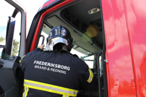 Brandmand fra Frederiksborg Brand og Redning på vej ind i køretøj