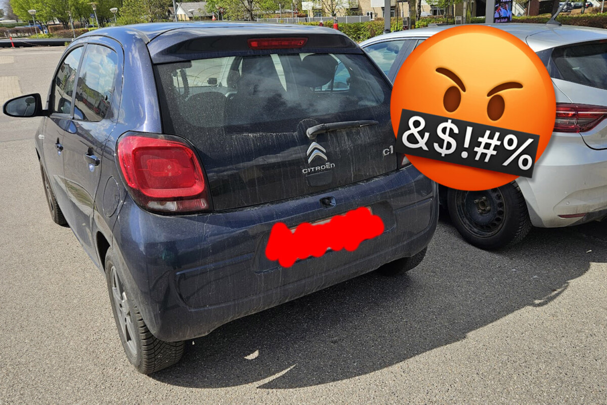 Bil med sløret nummerplade og sur smiley