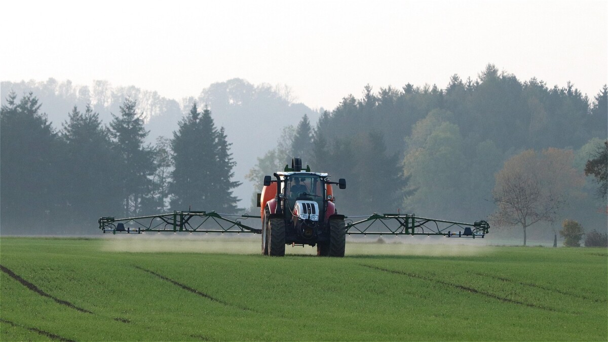 Traktor sprøjter på mark
